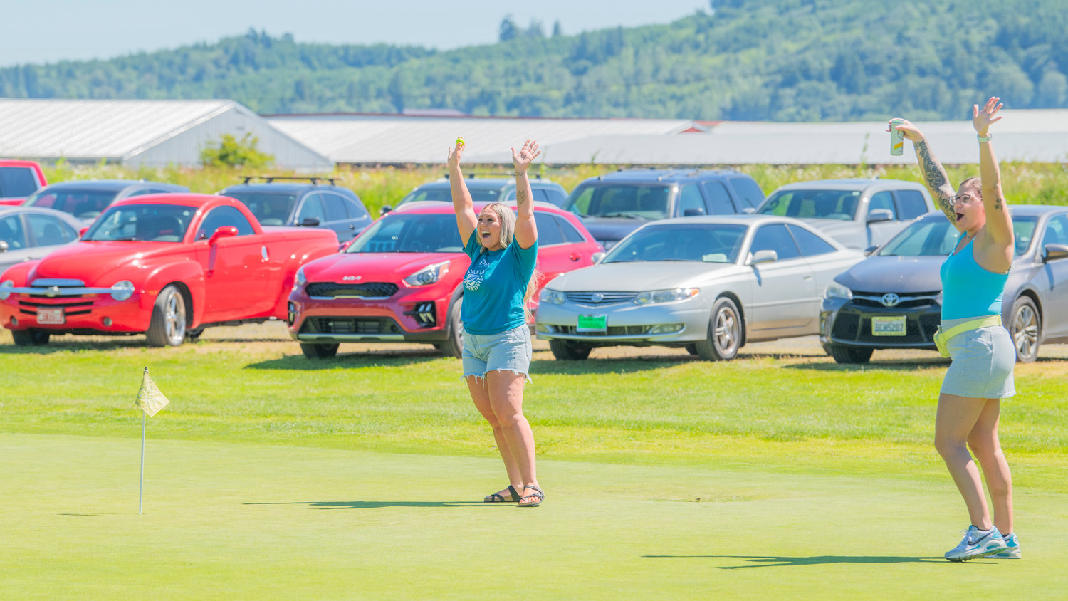 Amber Taylor et Jordan Prosser sourient et applaudissent lors d'un tournoi de golf caritatif pour collecter des fonds pour la Hope Alliance.